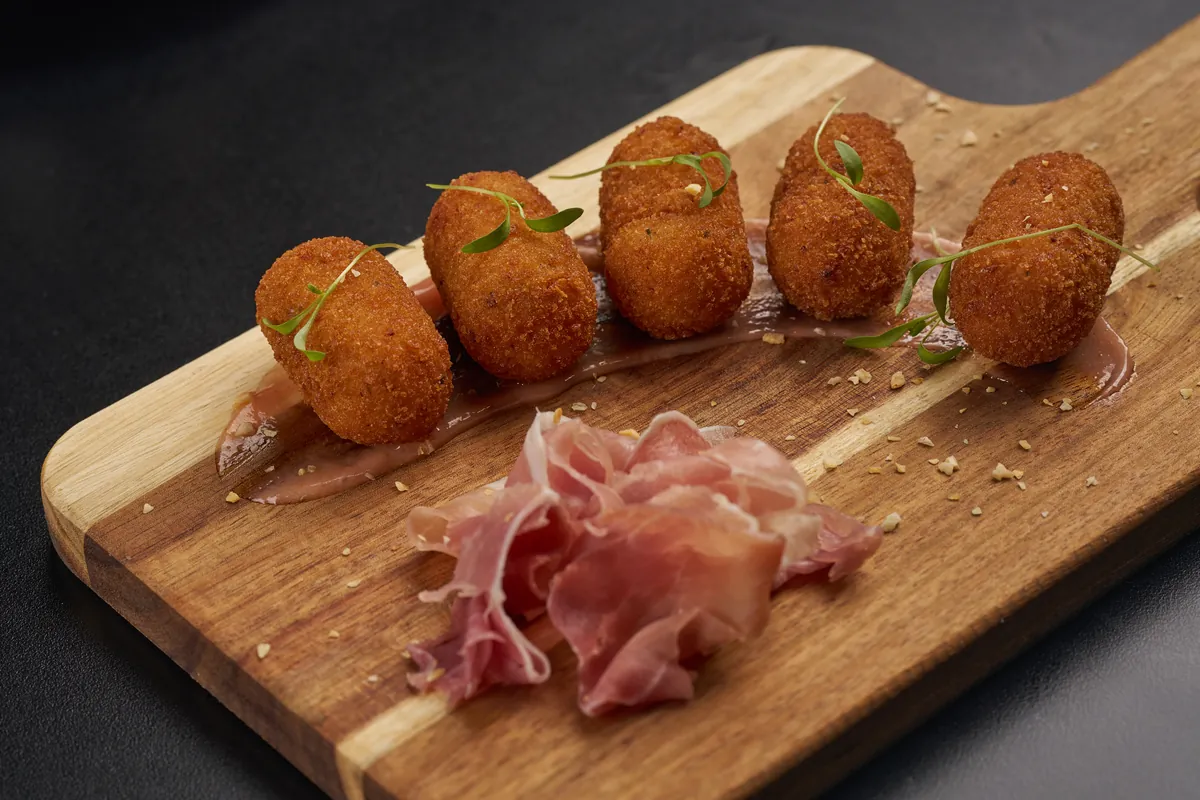 Hand-rolled Cuban ham croquetas with crispy golden crust served with aioli — classic Cuban appetizer at Lo D'Alex Restaurant Calle 8 Miami